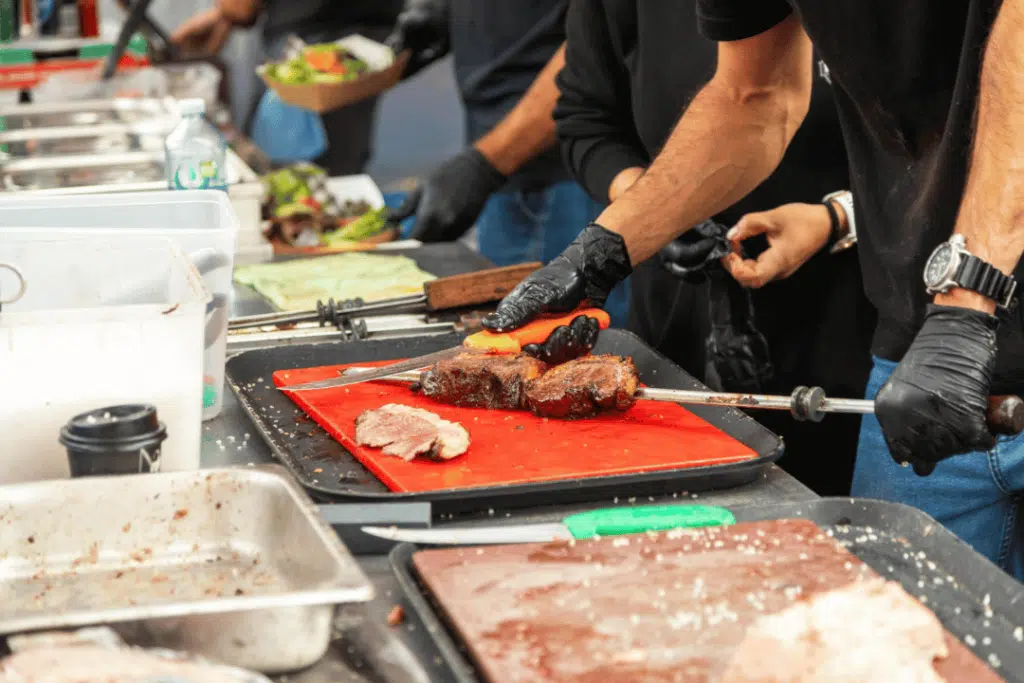 BBQ meat being freshly sliced at NY Firehouse Grille kitchen prep station